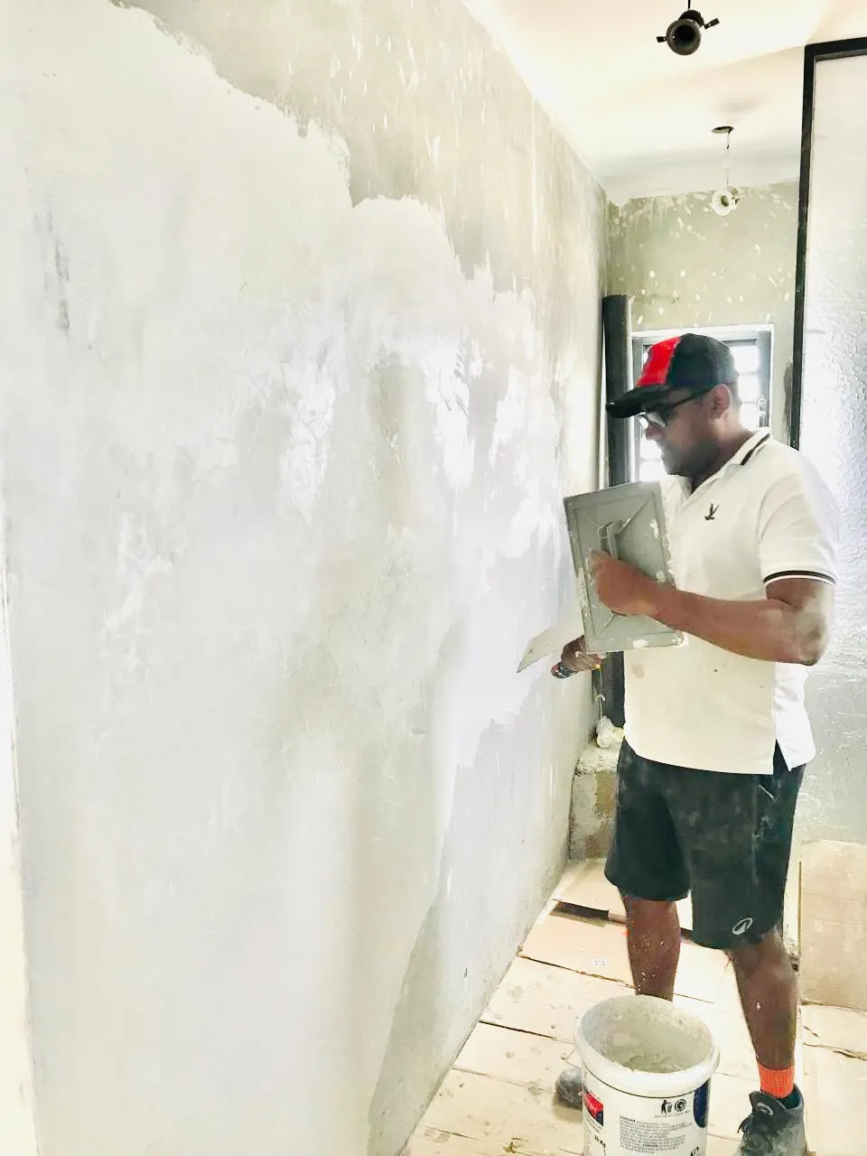 Worker applying interior plaster finish
